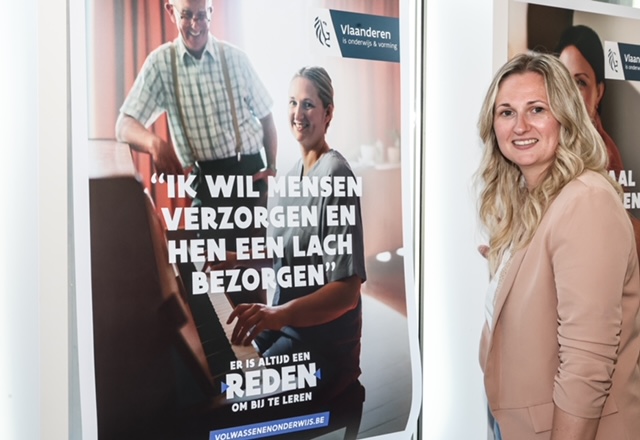 Celine Blomme glimlacht presenteert affiche campagne opleiding zorgkundige
