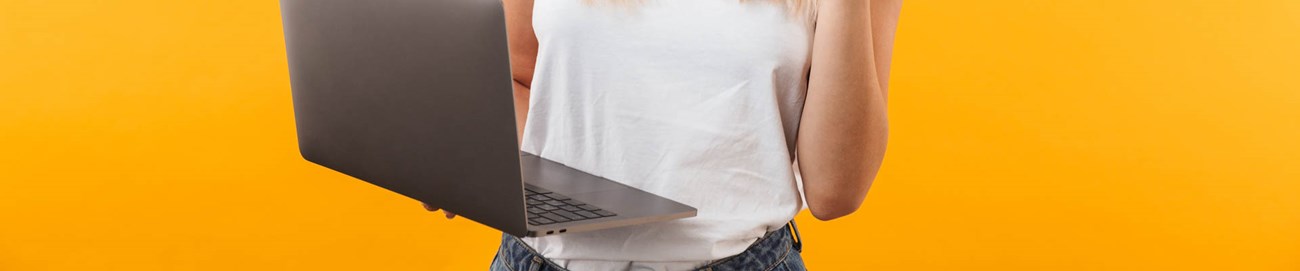 alt="jonge dame glimlacht en houdt laptop in de hand"