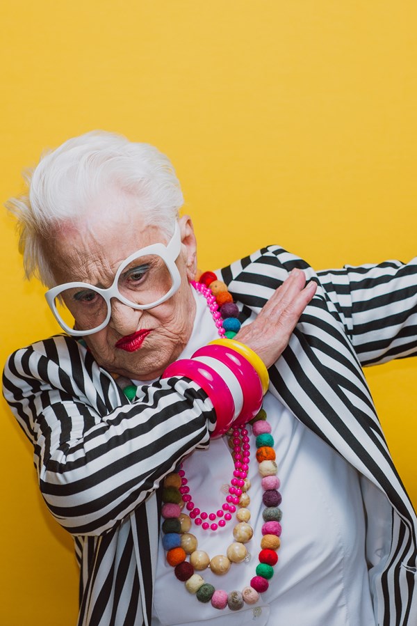 alt="hip geklede oude dame maakt dansend gebaar"
