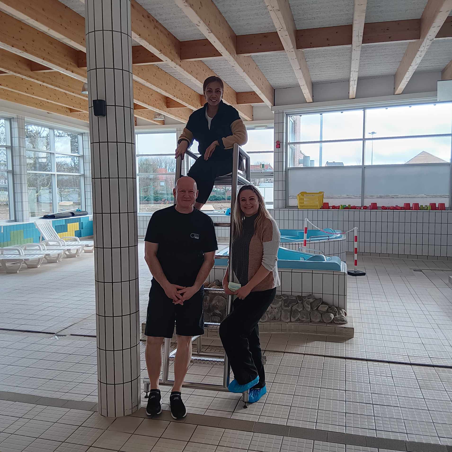 Twee werknemers van het publieke zwembad en de leerkracht 