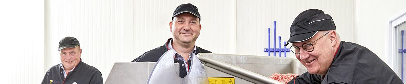 Drie leerkrachten slagerij maken gehakt en lachen 